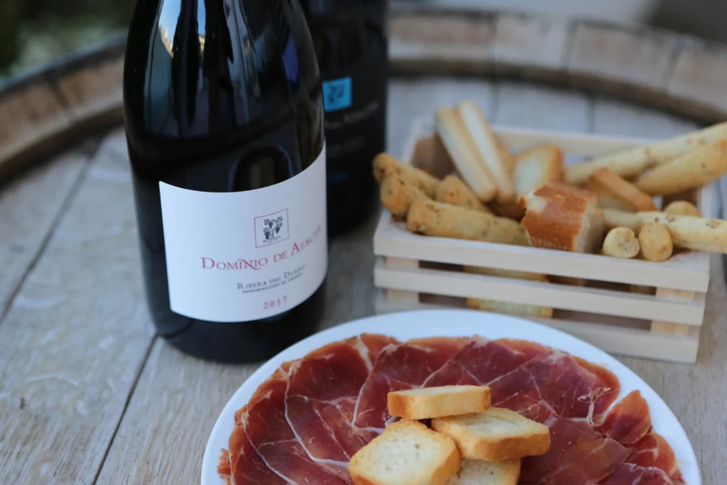 Opciones de maridaje junto a una botella de un vino de Dominio de Atauta. Esta imagen se utiliza para ilustrar una entrada sobre ideas de maridaje para un vino Ribera del Duero.
